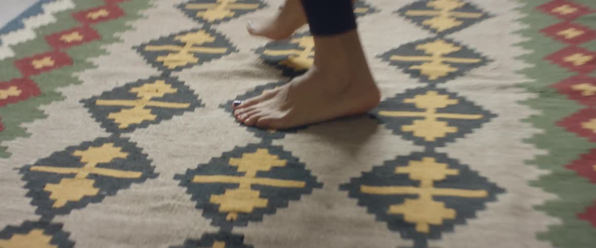 A womans feet moving fast in sprinting motion on a rug indoors at daytime