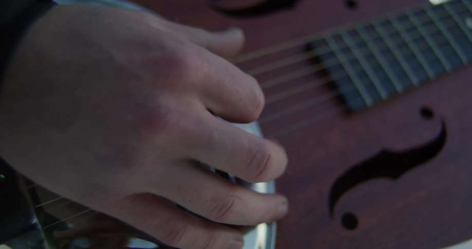 A man strums on an acoustical guitar