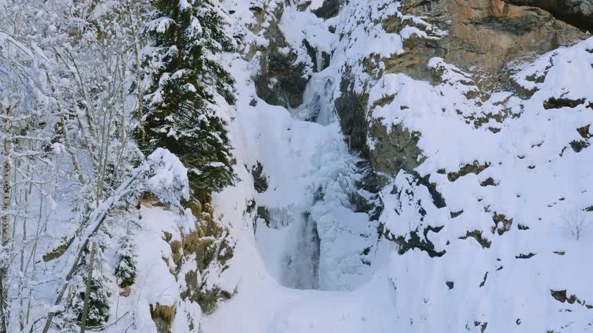 A river and a waterfall on a cliff covered with snow and ice