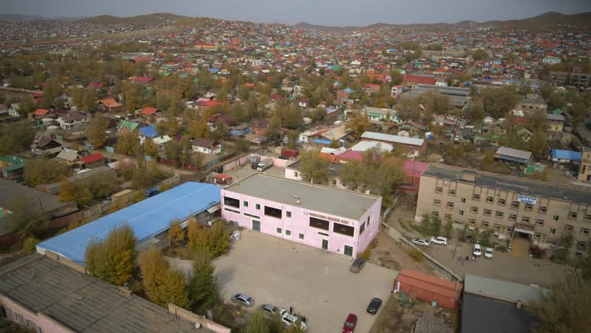 Buildings stretch to mist covered hills on the horizon