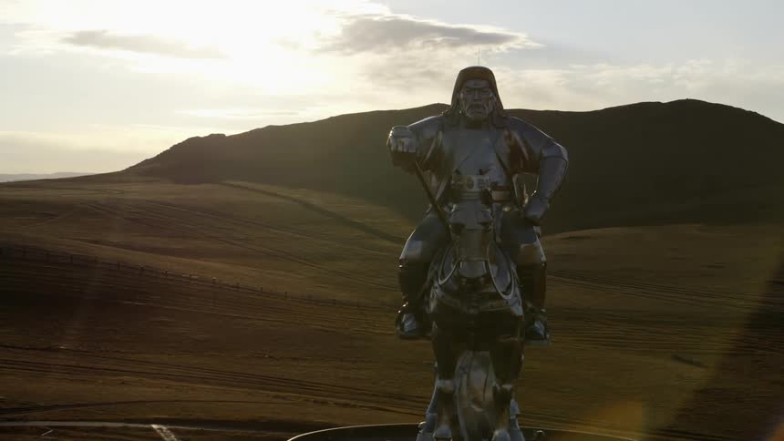 A monument on a hill overlooking a large field during the day