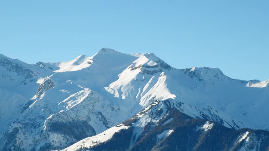 A snowy mountain ridge under a clear blue sky