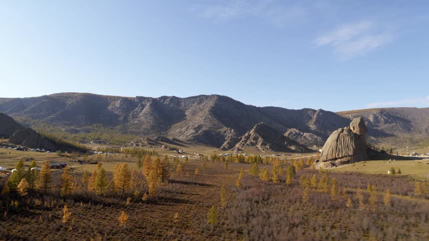 A landscape with trees with a mountain range the sky and clouds in the background