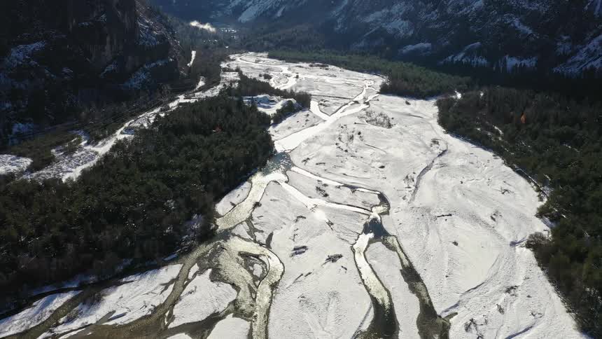 An aerial view of a river at the base of mountains
