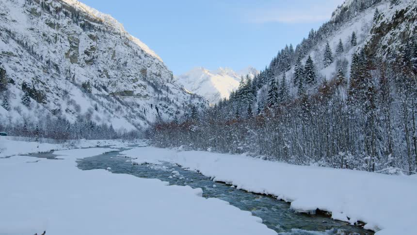 A view of a river running through a frozen area with snow