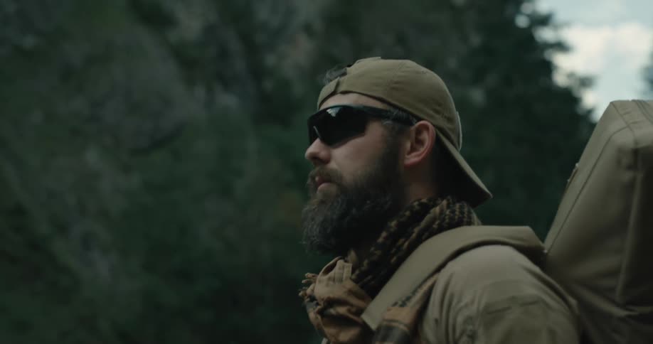 A soldier walking with a gun on his back