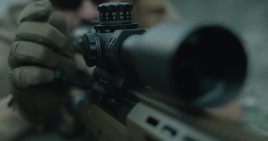 Man makes adjustments to rifle as he aims