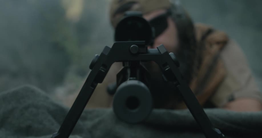 A man looks through a barrel as he aims a gun