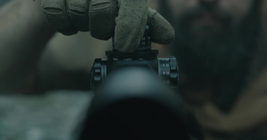 Man wearing gloves adjusts setting on viewfinder