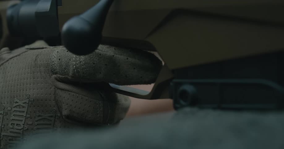 A person grabbing a trigger on a sniper rifle