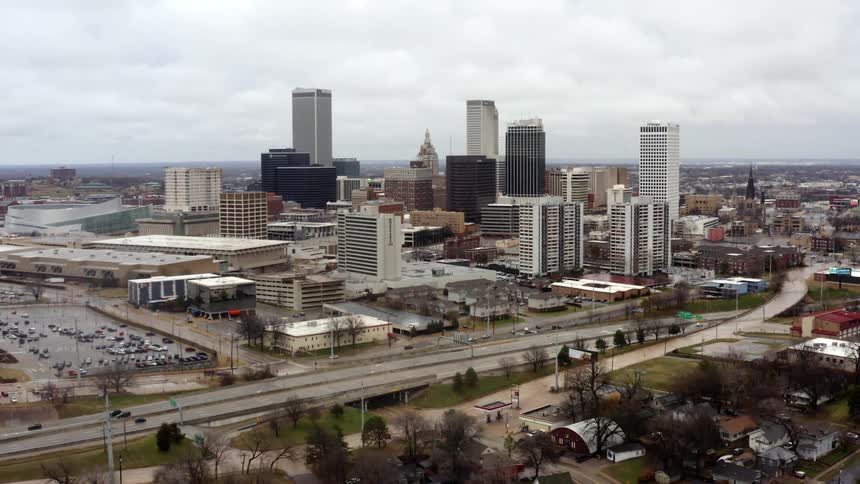 A city with buildings and trees with the sky and clouds in the background