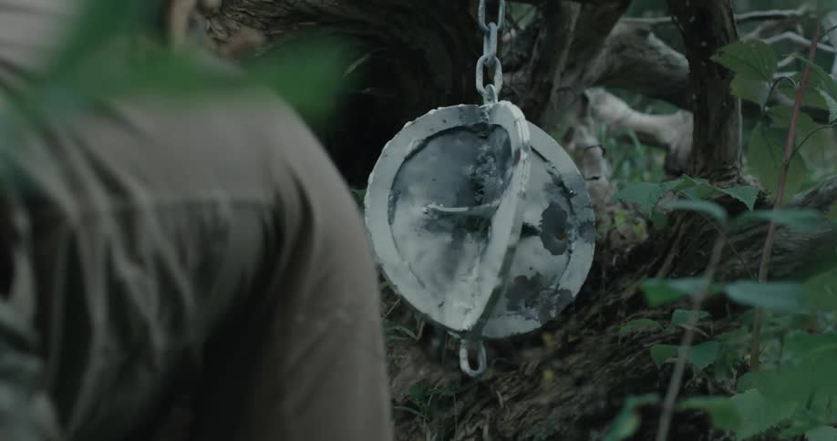 A military person hanging a weight and chain from a plant