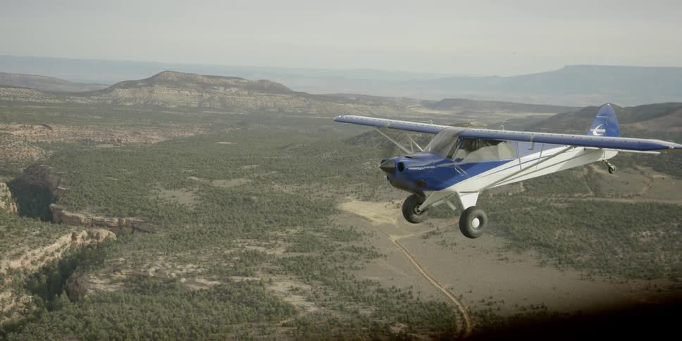A small blue and white single engine plane in flight