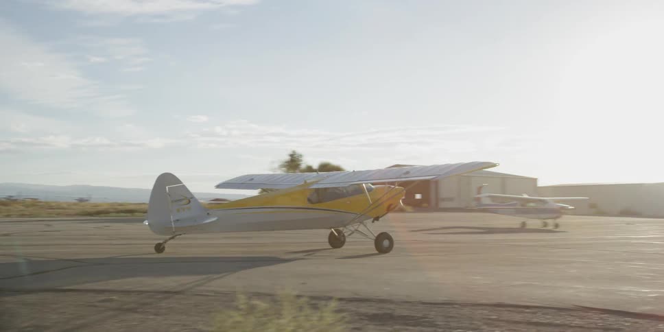 A single-engine plane taxis from the runway toward an airport