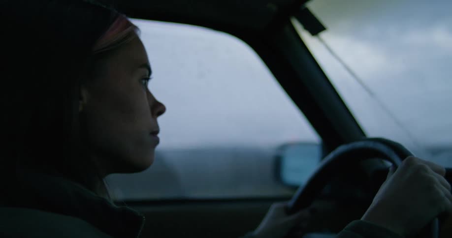 A woman quickly turns her steering wheel as she reverses and goes forward into traffic