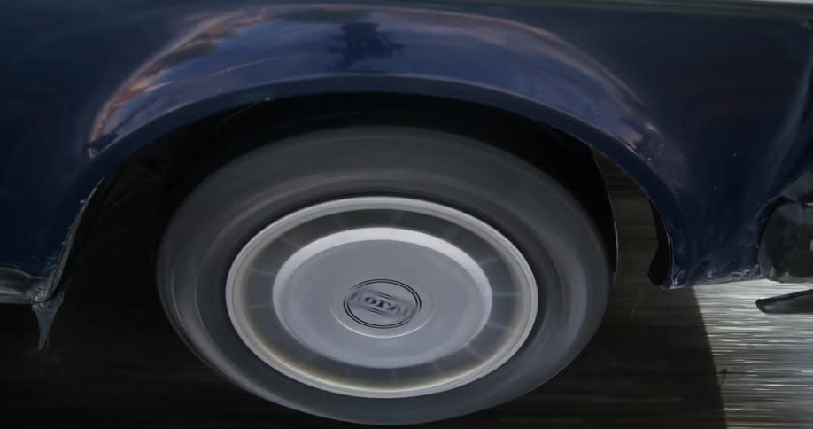 A car tire traveling on a paved road