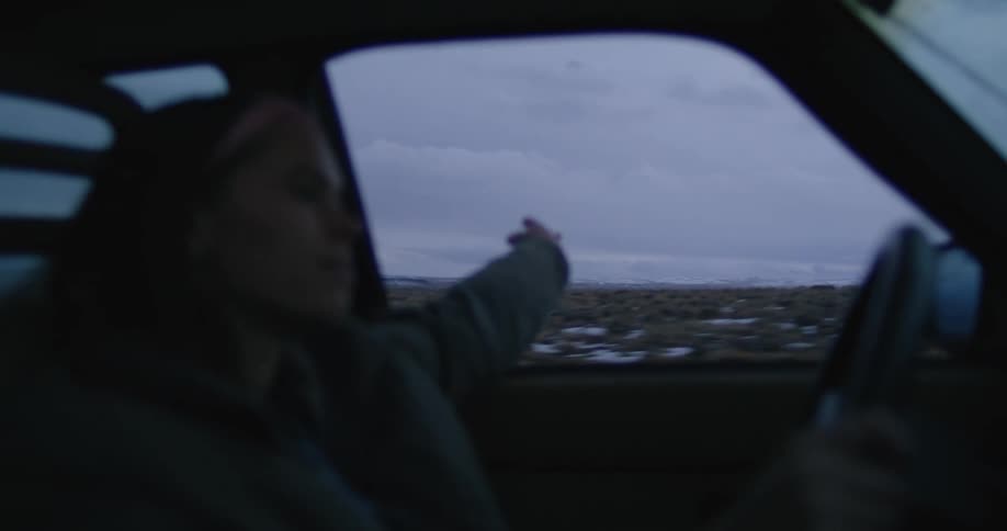 A woman driving a car down a road