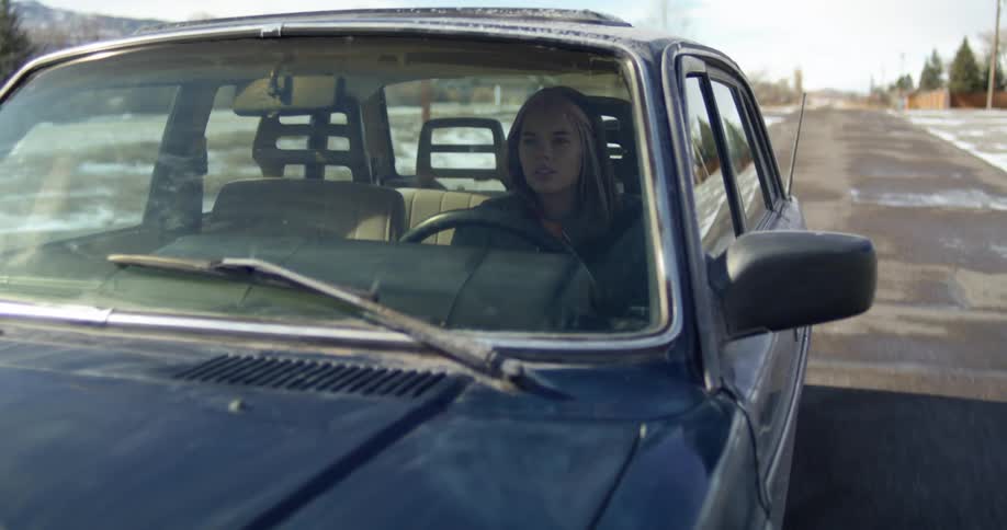 A woman driving on a paved road on a winter day