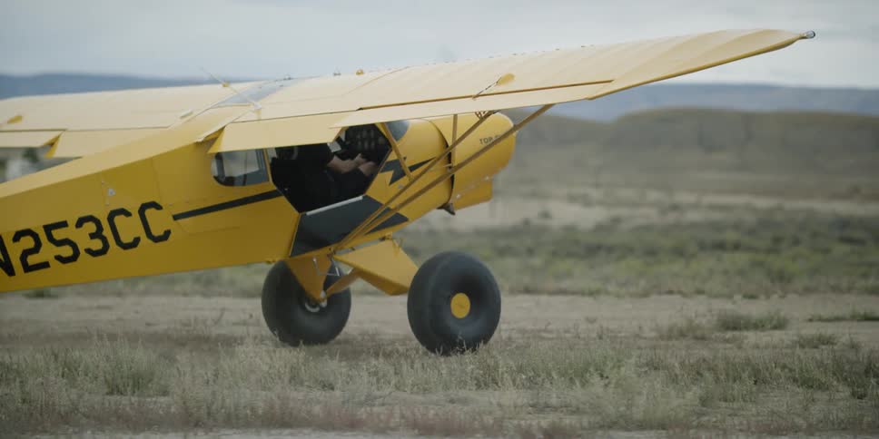 A small airplane drives in a rural field