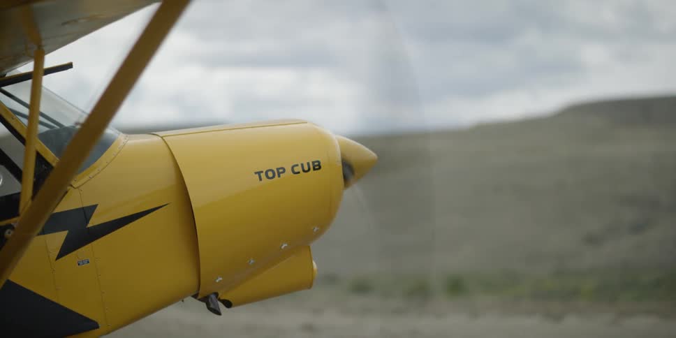 A yellow plane on a cloudy day