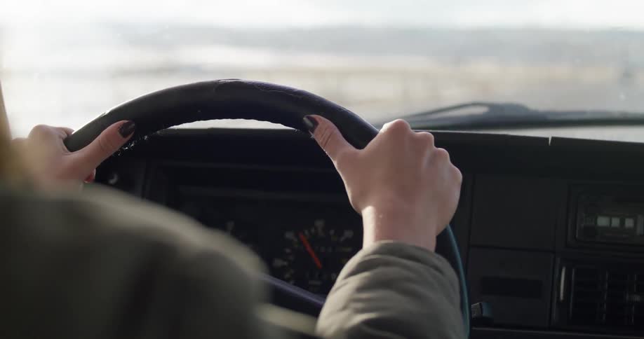 A woman driving a car down a road