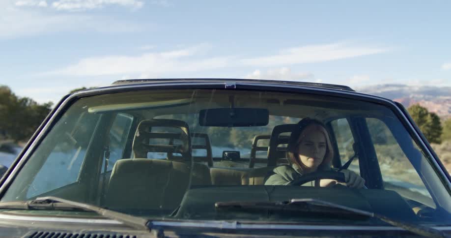 A woman driving on a remote road on a winter day