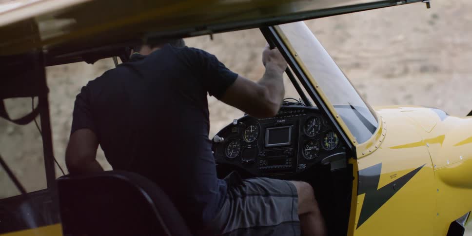 A pilot enters the cockpit of a small aircraft