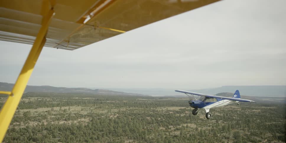 View out of a plane of another plane flying nearby