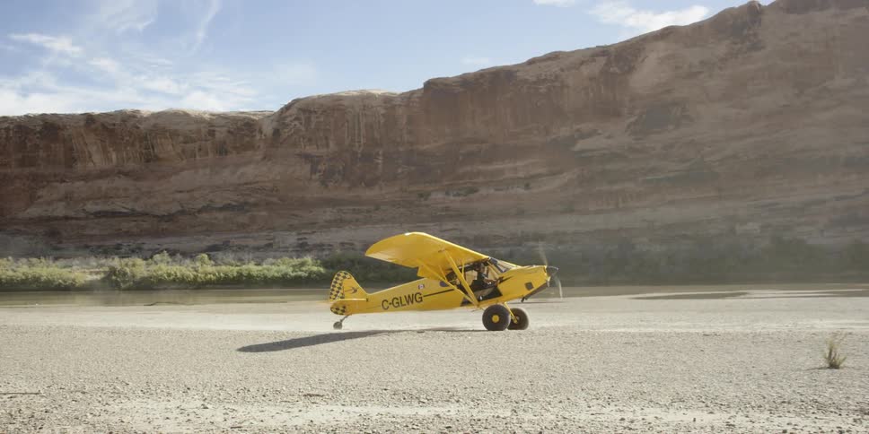 A yellow plane slowly moves on a field