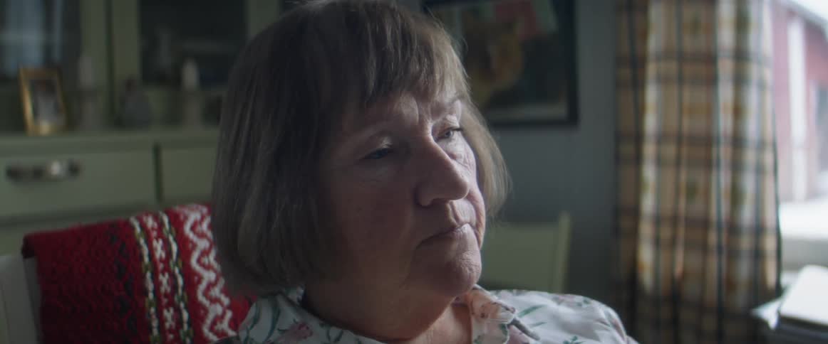 Woman sitting on the living room takes her glasses out looking bored at home