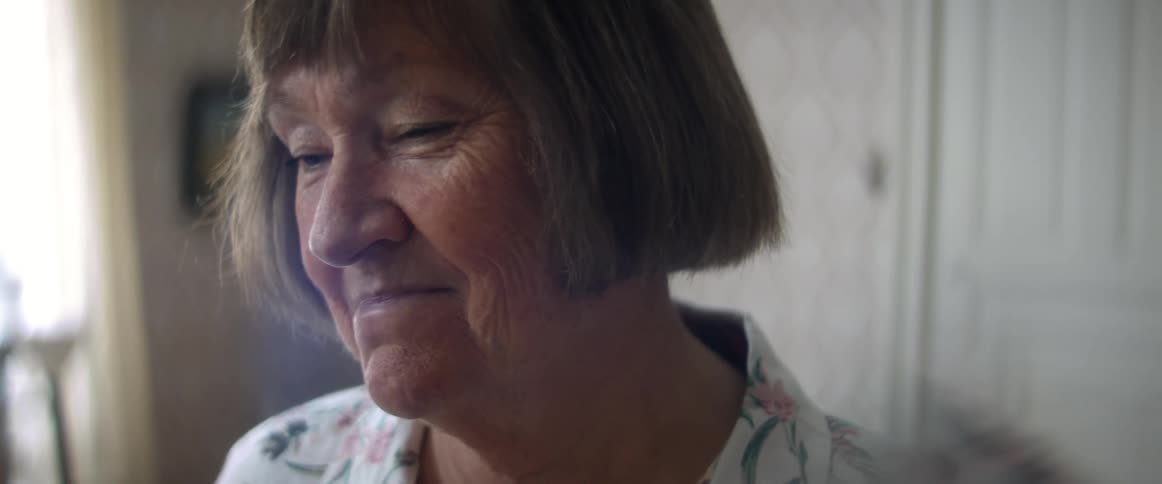 An elderly woman at home smiles