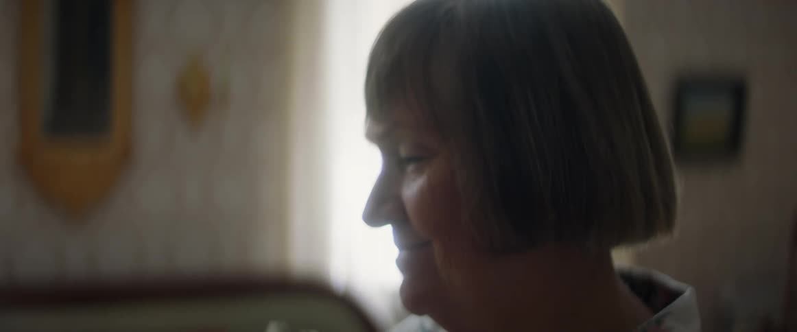 Woman looking at framed pictures in the living room at home