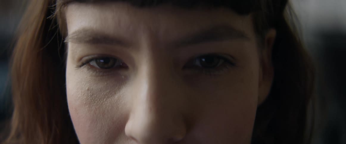 A womans brow wrinkles a bit as she talks and nods during a conversation