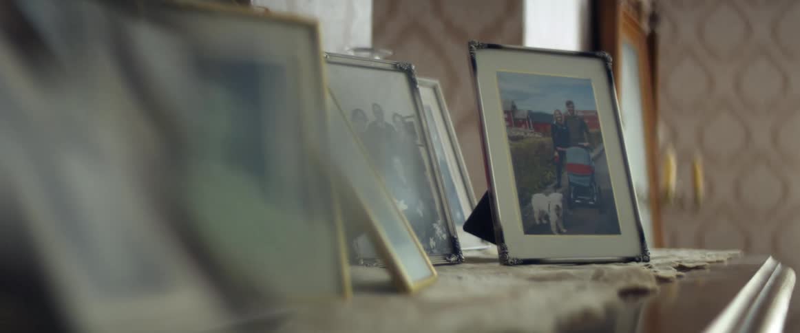 Framed portraits over a cabinet in the living room