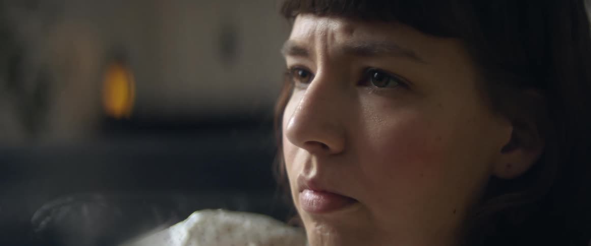 Close up of a teenage girls face as she sits at home and looks troubled