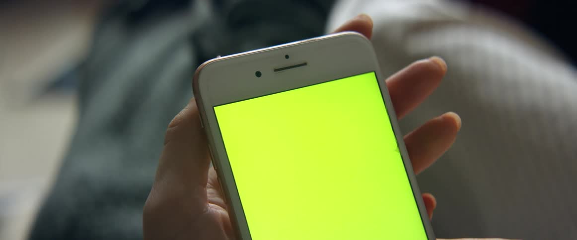 A woman in a room holding a smart phone