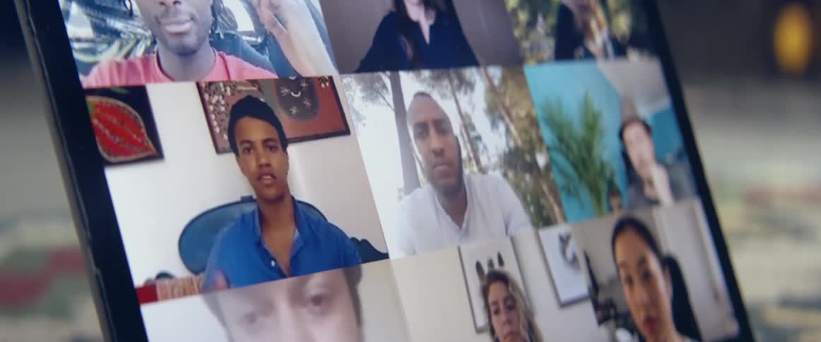 A group of people talking amongst one another on the screen of a laptop in a video call