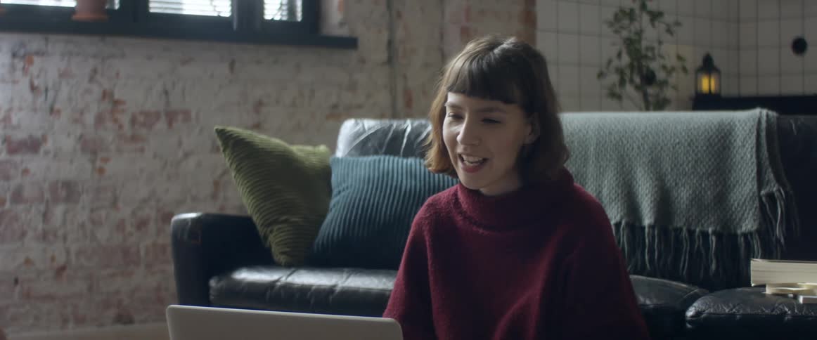 A woman talking to someone on a laptop