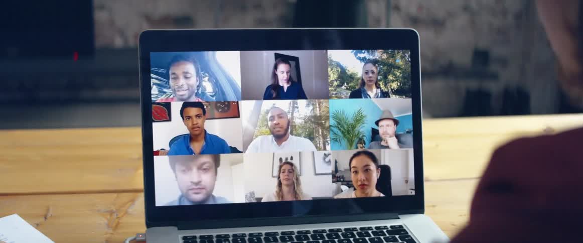 A group of people can be seen on a laptop screen as they participate in a video conference