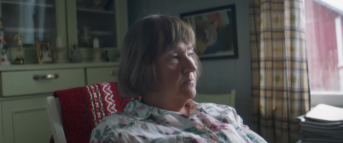 Woman sitting on the living room at home looking bored while looking out the window