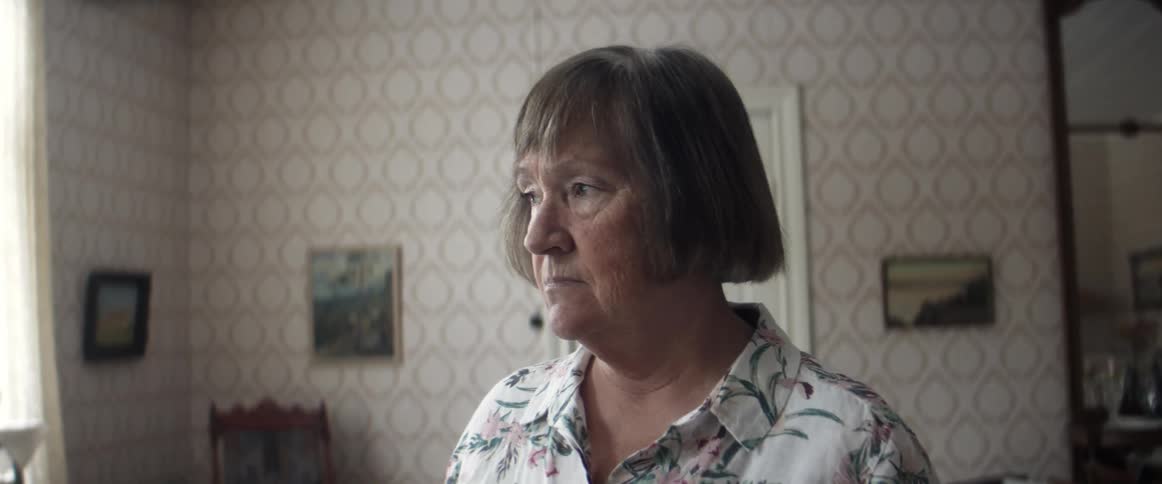 Woman standingin the living room at home looking sad