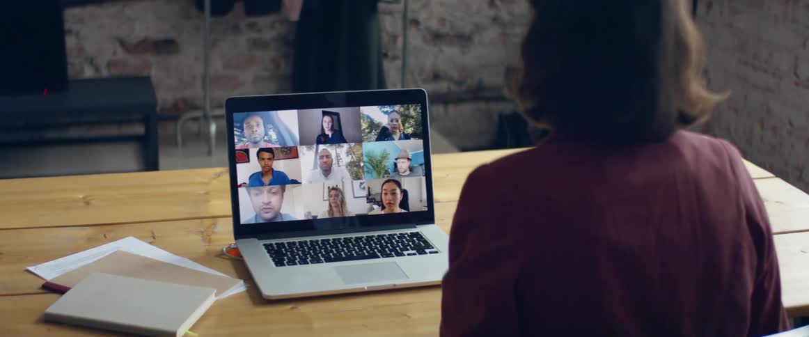 A woman talking to people on a laptop