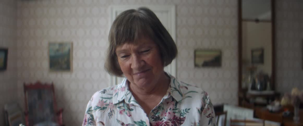 Woman standing on the living room briefly smiling