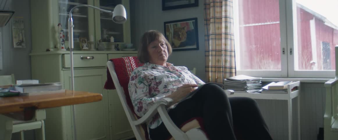Woman sits reading magazine then closes it with angry frown