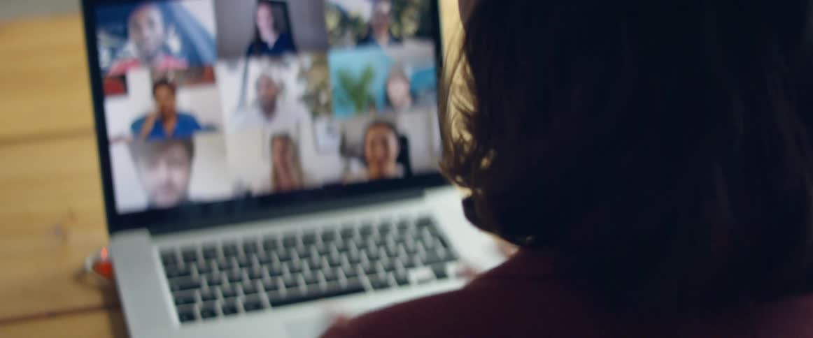 A woman sits in front of a laptop having a video call