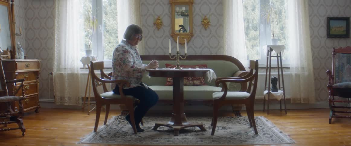 Woman playing solitaire in the living room at home