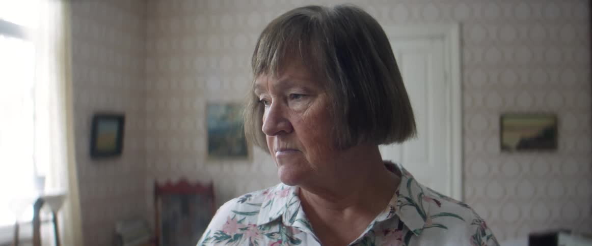Woman standingin the living room at home looking sad