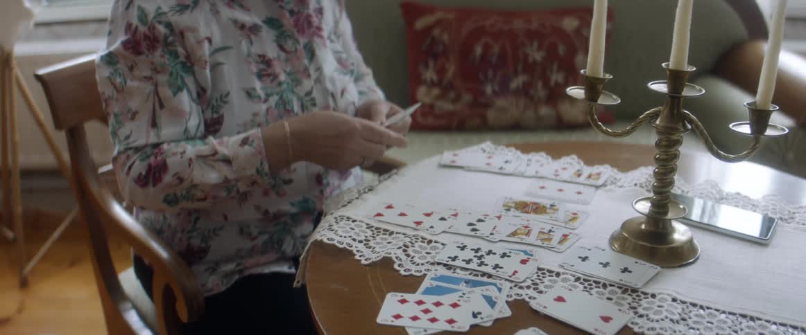 Woman playing solitaire in the living room at home
