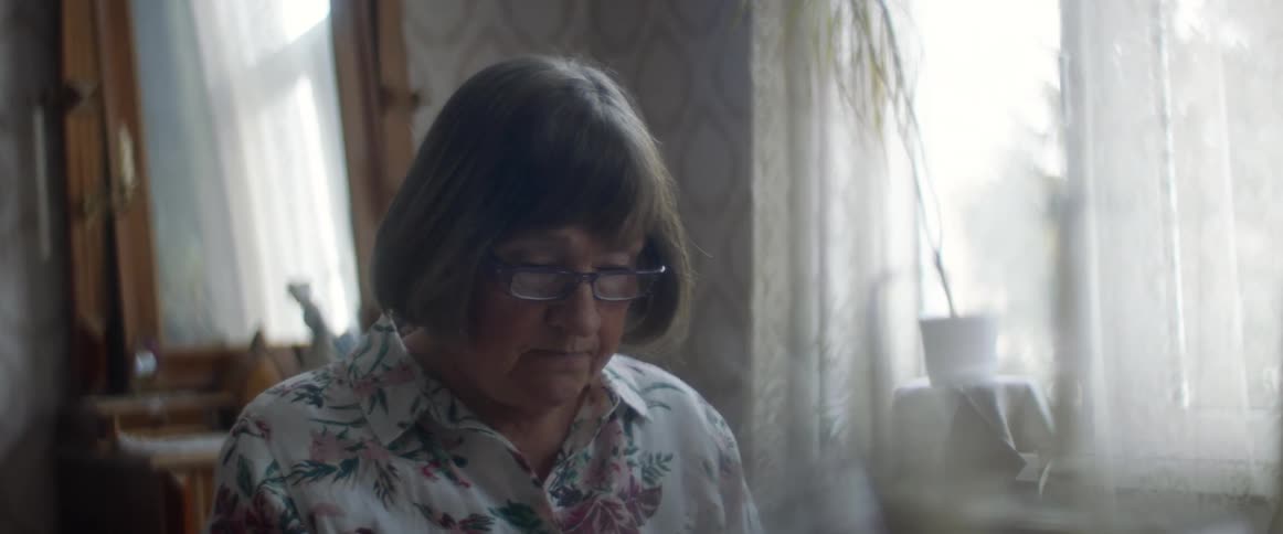 A woman looking sad sitting at a table in a room