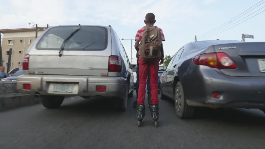 A group of people roller blade through a crowded city road